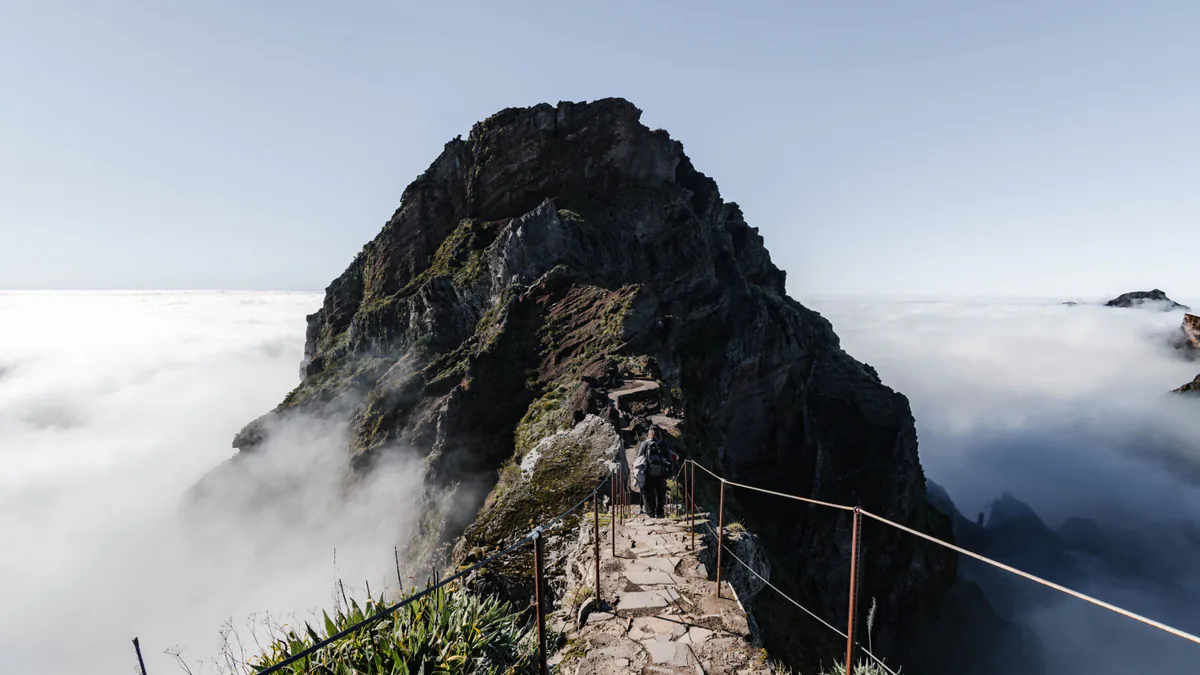 Sendero de montaña sobre un mar de nubes en Madeira