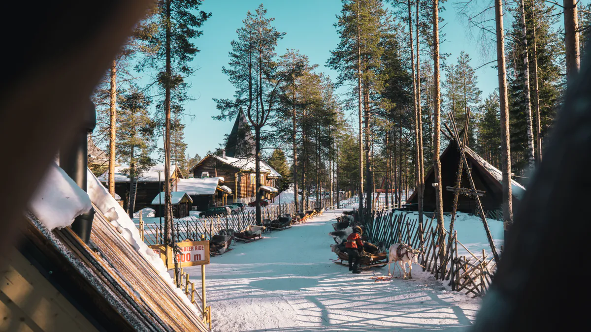 Paisaje nevado con renos y cabañas en Rovaniemi durante diciembre