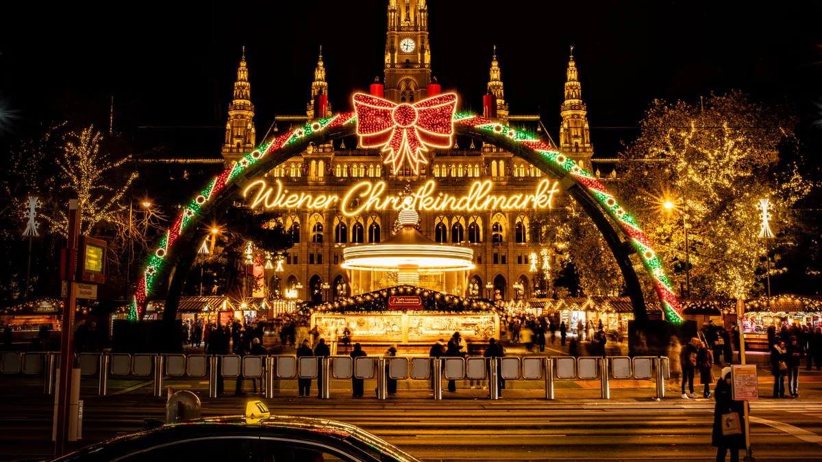 Mercado de Navidad frente al Ayuntamiento de Viena iluminado por la noche