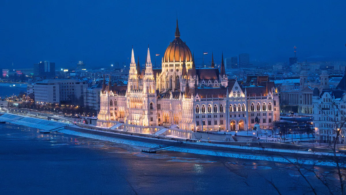 Parlamento de Budapest iluminado junto al Danubio en invierno
