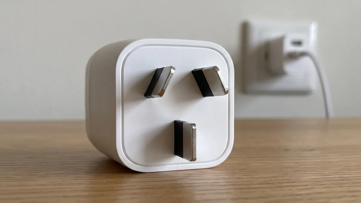 Adaptador con clavija tipo I delante de una toma de corriente de Nueva Zelanda