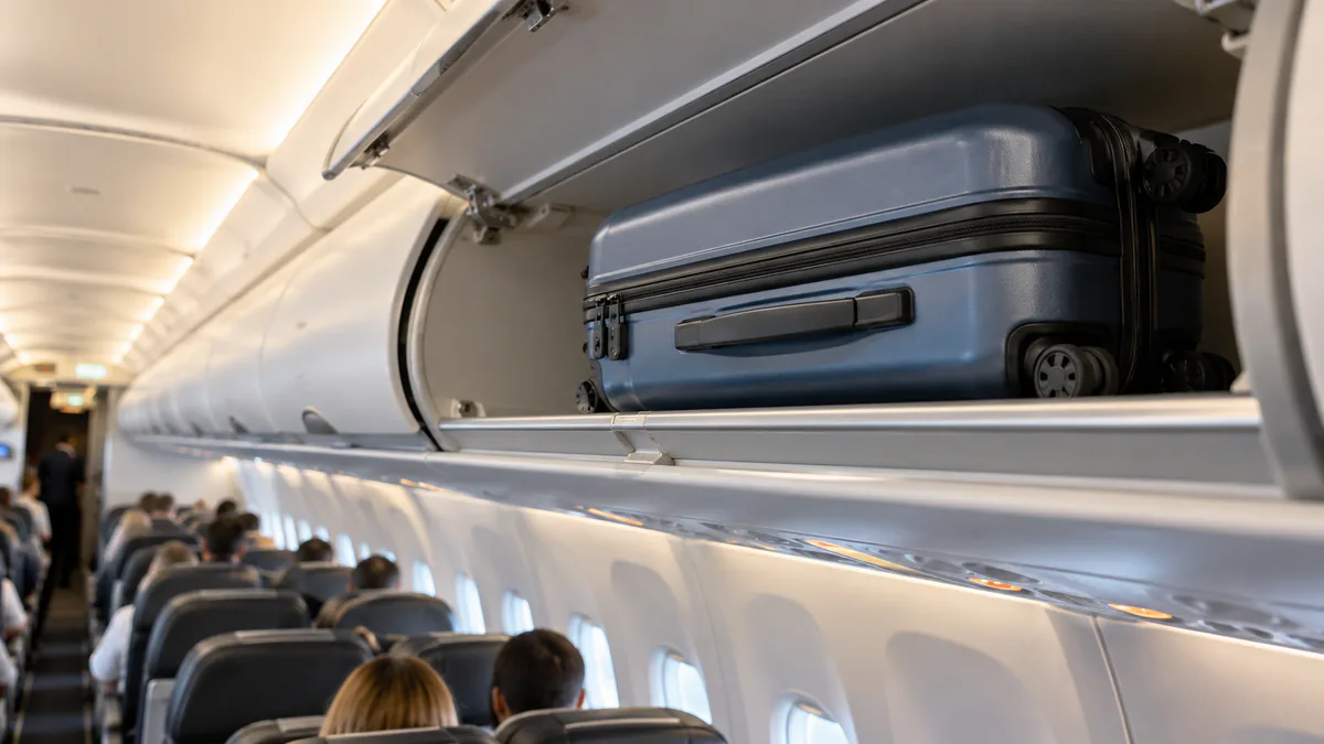 Maleta de cabina guardada en el compartimento superior de un avión