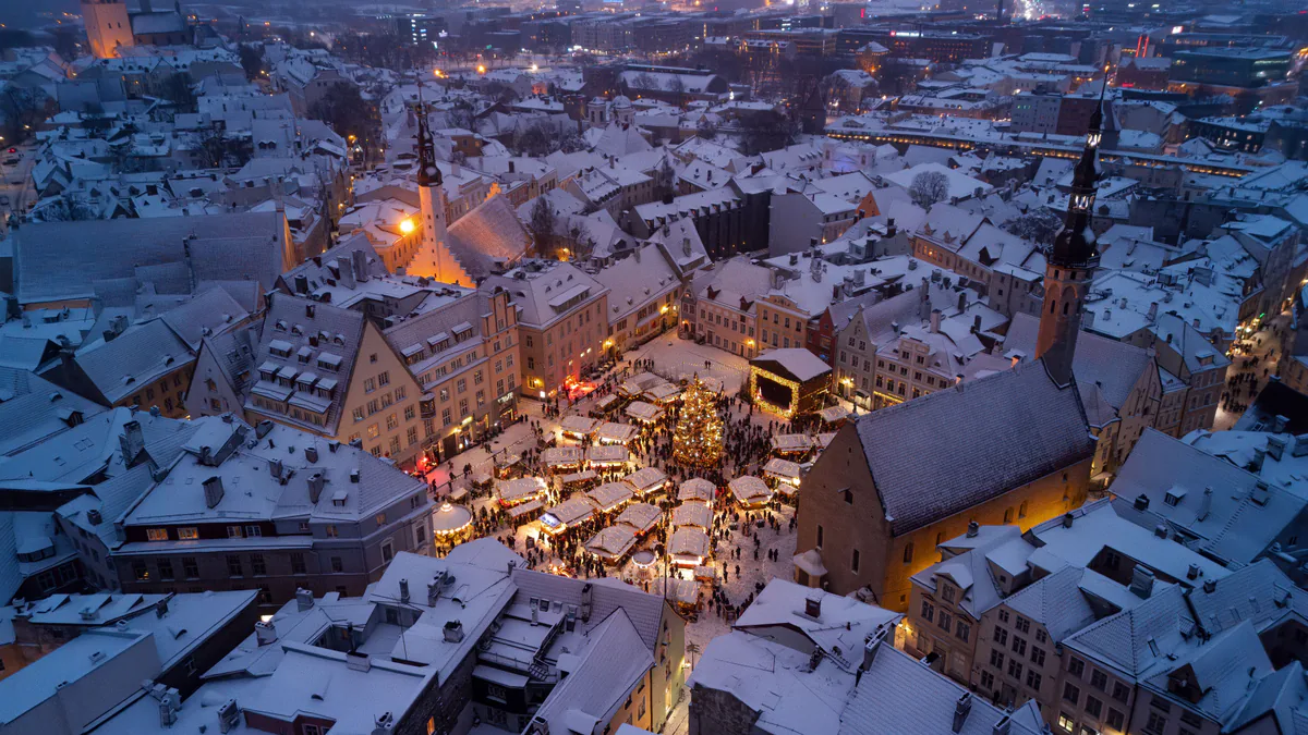 Casco histórico nevado de Tallin con el mercado de Navidad en Raekoja plats